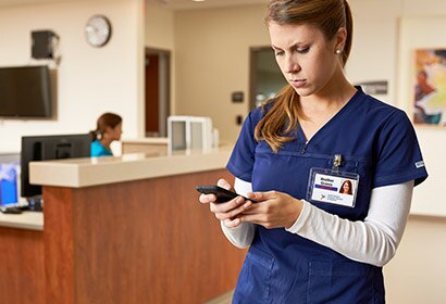 A caregiver is using mobile device to access patient data.
